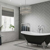 Luxury grey Herringbone pattern wall panels installed in a bathroom with a free standing bath.