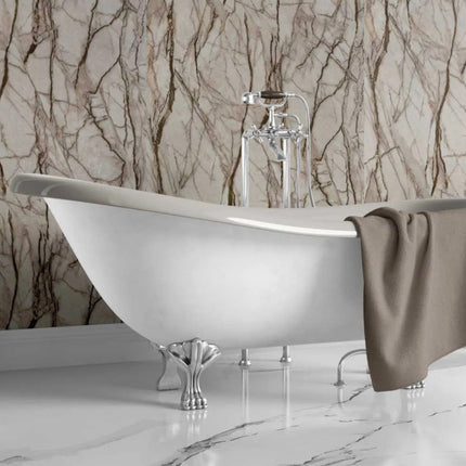 Freestanding bathtub with a towel against a marble-patterned wall.