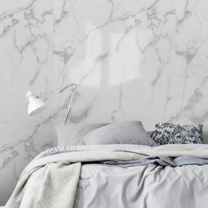 Bedroom with marble wall, books, and a lamp