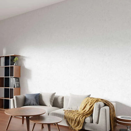 White Stone Maxi Panel walls in a Modern living room with a gray sectional sofa, wooden coffee table, and bookshelf.